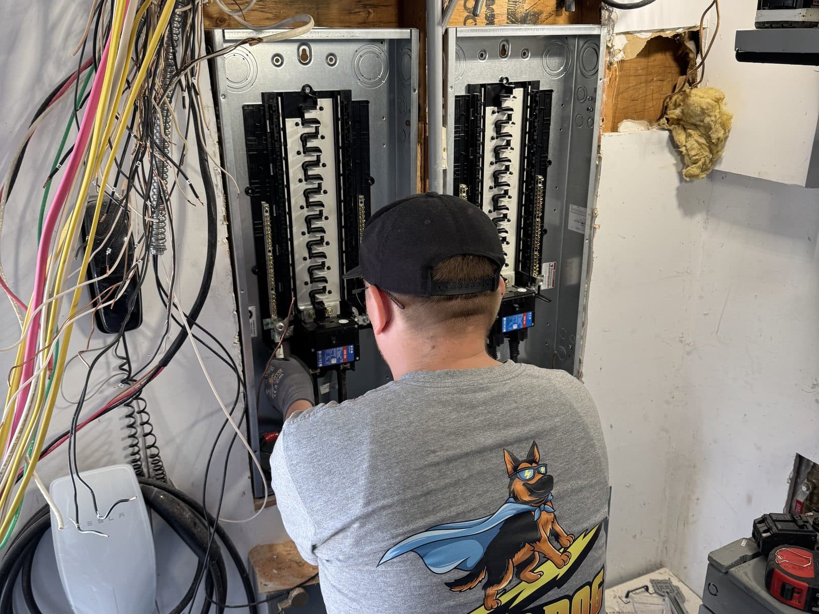 Mad Dog Electric electrician wiring twin electrical panels in a garage